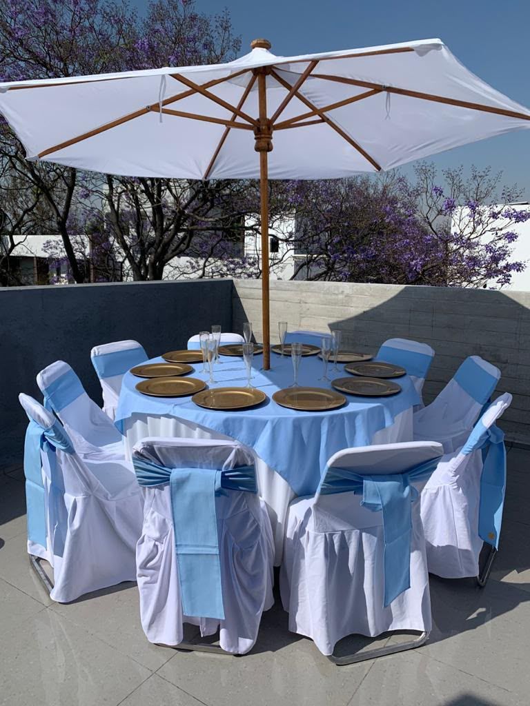 Mesa redonda con sillas vestidas en terraza